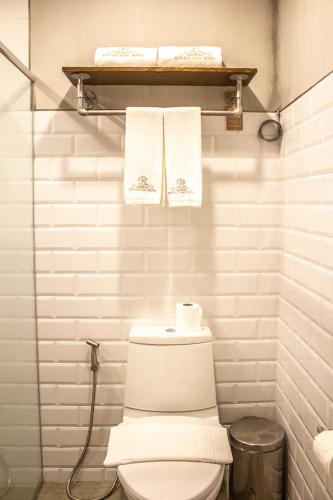 a bathroom with a toilet and towels on a shelf at Royale Parc Hotel Tagaytay in Tagaytay