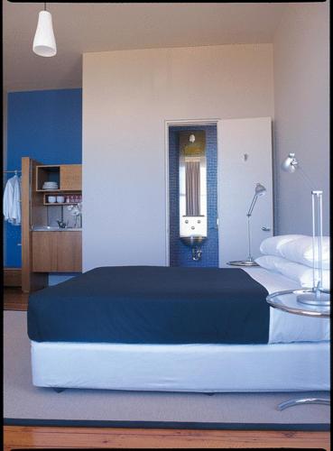 a bedroom with a large bed and a blue wall at Dive Hotel in Sydney