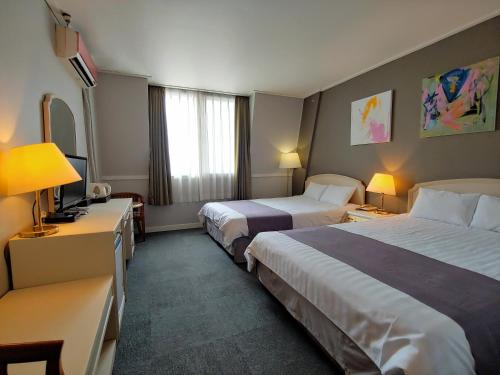 Ένα ή περισσότερα κρεβάτια σε δωμάτιο στο Pearl Hotel Jeju