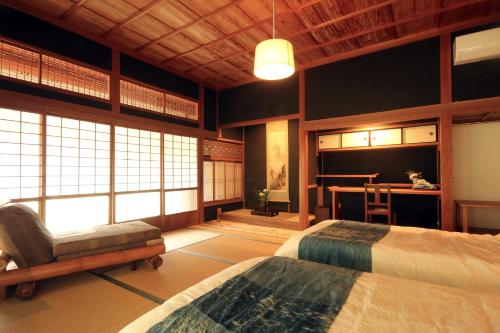 a bedroom with two beds and a desk and a table at HÏSOM in Ōda