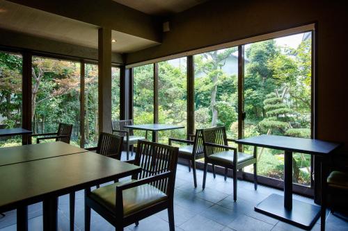 嬉野市にある嬉野温泉　旅館吉田屋のテーブルと椅子と大きな窓のあるレストラン