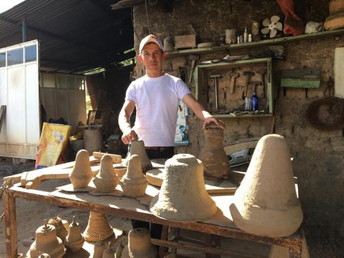 a man making clay pots on a table at La Estancia de la Pradera Cabana Fiba in Nobsa