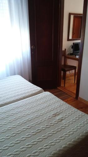 a bedroom with a bed and a window and a desk at Hotel El Sueve in Colunga