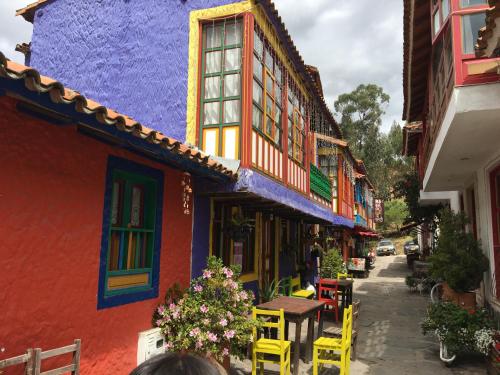 a street with colorful buildings and tables and chairs at La Estancia de la Pradera Cabana Fiba in Nobsa