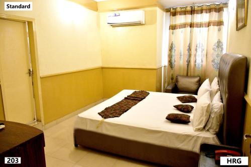 a bedroom with a bed with pillows on it at Hotel Royal Gardens Lahore in Lahore