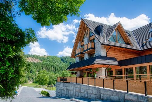 uma casa de madeira com um telhado de gambrel em Hotel Litworowy Staw em Białka Tatrzanska