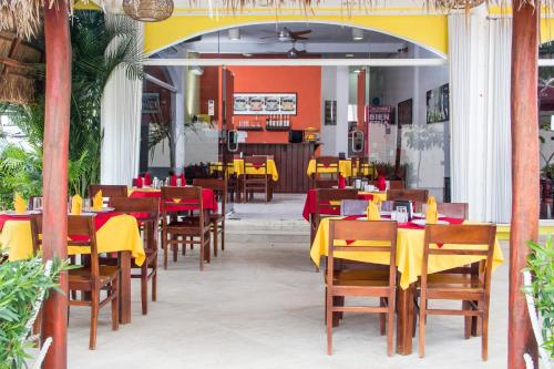 um restaurante com mesas e cadeiras vermelhas e amarelas em Hotel Sol Playa em Playa del Carmen