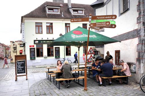 a group of people sitting at a table under an umbrella at Pension U Tří sedláků in České Budějovice