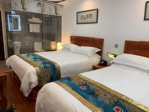 a bedroom with two beds and a shower at Qinfu Hotel Beijing Nanluogu Lane Houhai in Beijing
