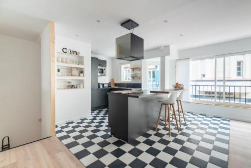 - une cuisine avec un sol en damier noir et blanc dans l'établissement L'appart, à Le Touquet-Paris-Plage