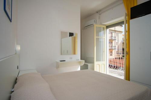 um quarto branco com uma cama e um lavatório em Delfino em Marina di Camerota