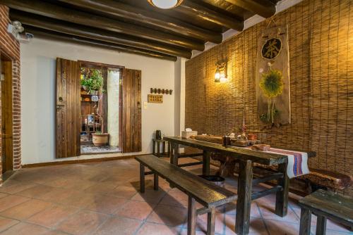 a room with a table and benches and a window at Chaozhou Hello Inn in Chaozhou