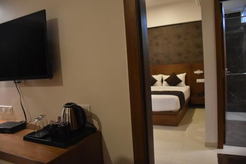 a hotel room with a bed and a television at Heritage Inn in Mysore