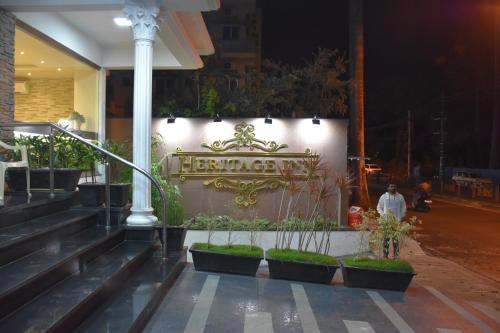 a sign on the side of a building with plants at Heritage Inn in Mysore