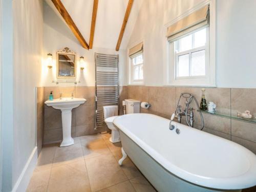 y baño con bañera y lavamanos. en Pinley Hill House, en Warwick