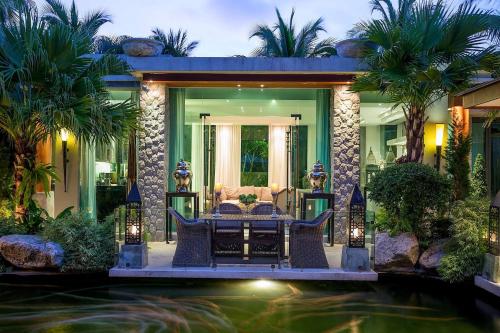 a house with a pond in front of a house at Villa on The Rocks, 4 bedrooms, Phuket in Surin Beach