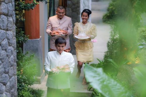 a group of people walking down the stairs with plates of food at Villa on The Rocks, 4 bedrooms, Phuket in Surin Beach