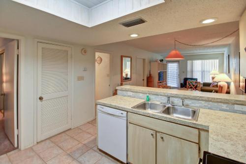 a kitchen with a sink and a living room at Surfside Condos in South Padre Island