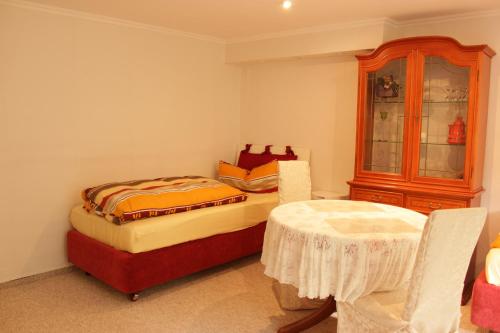 a bedroom with two beds and a table and a cabinet at Casa Susanne in Berlin