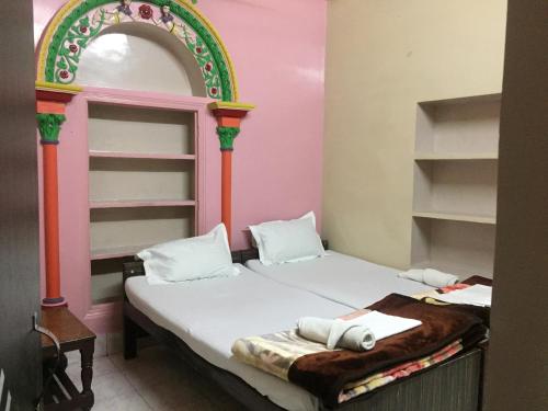 バラナシにあるババ ゲストハウスのアーチ型のベッドが備わる小さな客室です。