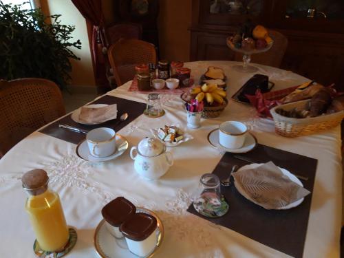 a table with a white table cloth with food and drinks at Sous les Remparts in Solignac