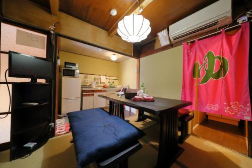 a small room with a table and a kitchen at Oyado Sanjo Machiya in Kyoto