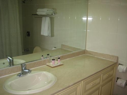 ein Bad mit einem Waschbecken und einem Spiegel in der Unterkunft Tumon Bay Capital Hotel in Tumon