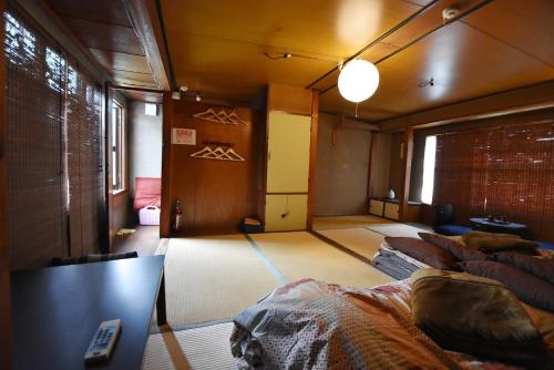 a room with three beds and a table in it at Oyado Sanjo Machiya in Kyoto