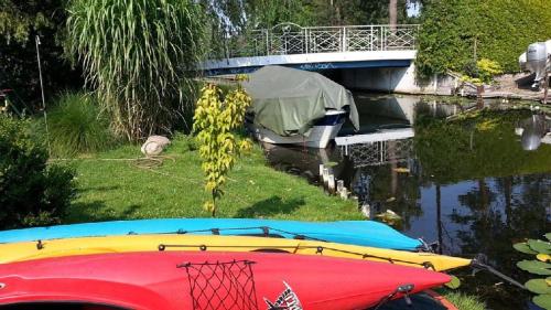 two boats parked on the grass next to a bridge at Pension an der Elsterbrücke in Berlin