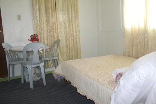 a bedroom with a bed and a table and chairs at Maraño's Home in Legazpi