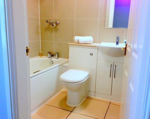 a bathroom with a white toilet and a sink at Ely House Hotel in Wolverhampton