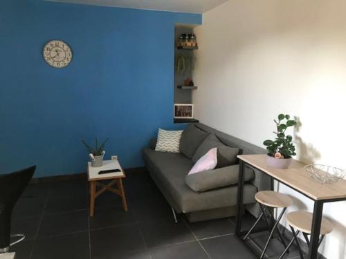 un salon avec un canapé et une table dans l'établissement Appartement moderne tout équipé, à Lorient