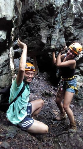 two people are posing in front of a cave at Ciudad de Las Rocas in La Fortuna Gallo Giro