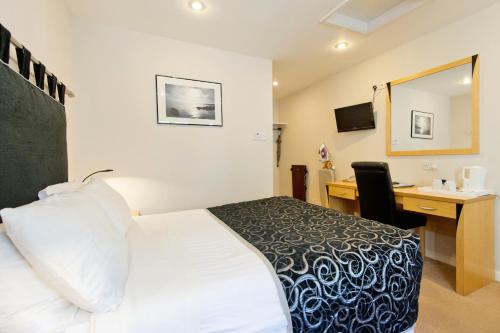 a hotel room with a bed and a desk at Station Hotel in Thurso