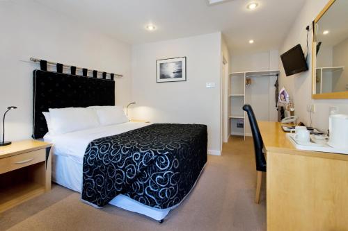a hotel room with a large bed and a sink at Station Hotel in Thurso