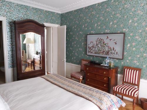 a bedroom with a bed and two chairs and a dresser at Le 48 Paris in Paris