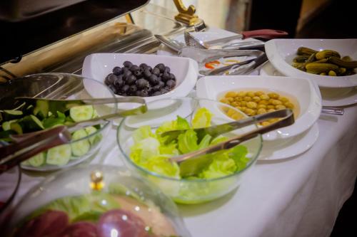 タシュケントにあるグロリア ホテルのテーブルの上に野菜やその他の食べ物が盛られたビュッフェ