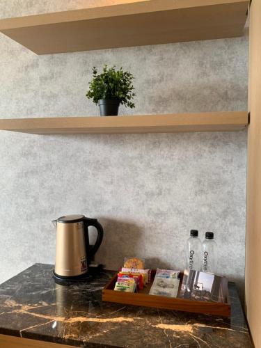 a table with a coffee pot and books on a counter at Two Easy Inn in Jiufen