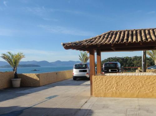 a car parked in a parking lot next to the water at Pousada Casa Atlântica in Angra dos Reis