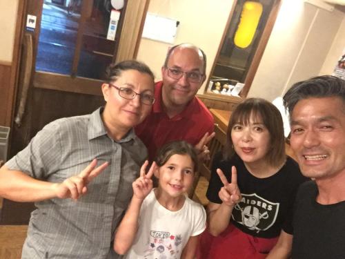 a group of people giving the peace sign with their hands at Guest house daisho oshiro asobi in Matsue