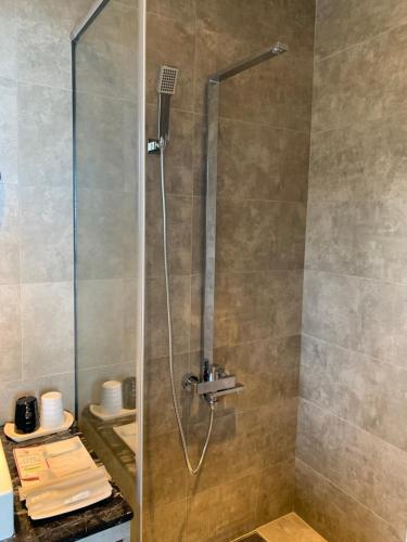 a shower with a glass door in a bathroom at Two Easy Inn in Jiufen