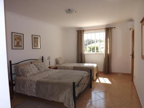 a bedroom with two beds and a window at Apartamento Mariamar in Olhos de Água