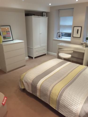 a bedroom with a large bed and a desk and a desk at Fabulous Double ensuite room in Sefton Park Lark Lane in Liverpool