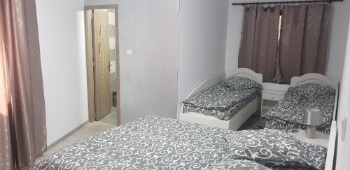 1 dormitorio con 2 camas y espejo en Pensiunea Gallamar en Bîrlad