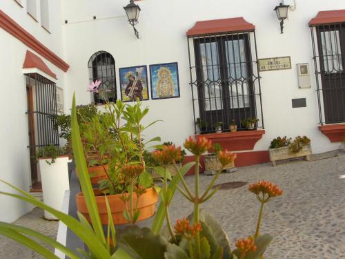 a building with some plants and pictures on the wall at Hotel El Convento in Arcos de la Frontera