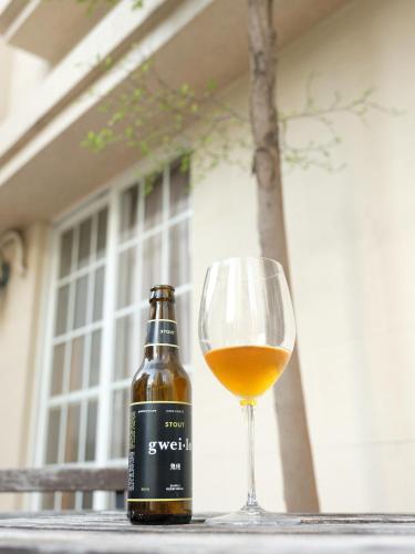 una botella de vino junto a una copa de vino en Backpacker 41 Hostel - Kaohsiung, en Kaohsiung