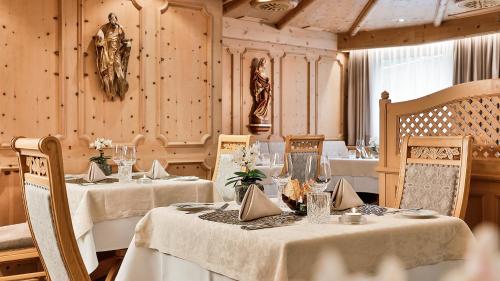 a dining room with two tables with white tablecloths at Das Homann in Samnaun