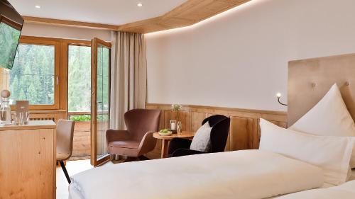 a hotel room with a bed and a table and chairs at Das Homann in Samnaun
