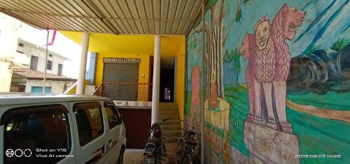 un mur orné d'une fresque murale sur le côté d'un bâtiment dans l'établissement MAYUR paying Guest house, à Varanasi