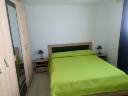 sypialnia z zielonym łóżkiem i 2 stolikami nocnymi w obiekcie Tenerife Costa del silencio w mieście Costa Del Silencio